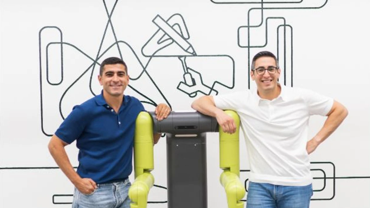 Maven Robotics co-founders Hamza and Khalid Derbas standing beside the company’s industrial robot