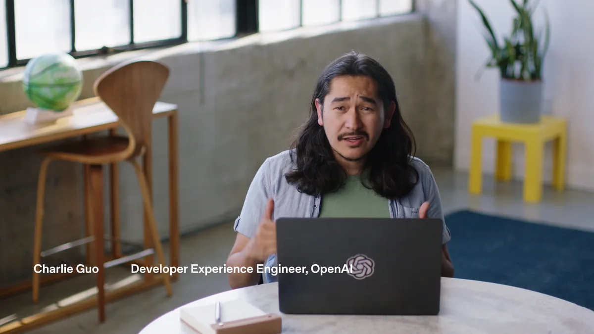 OpenAI developer experience engineer Charlie Guo speaking behind an OpenAI laptop in the Agents API launch video